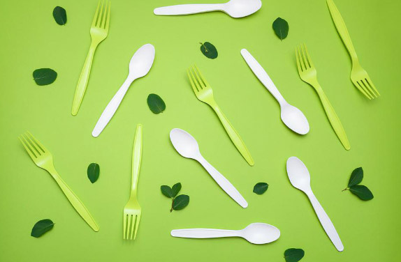 Plastic Fork and Spoon in green background