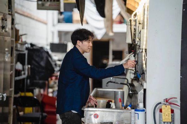 Man Using Machinery in a Factory